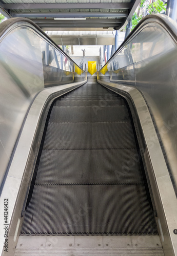 The empty modern escalator that is not yet in operation inside the suburban train station.