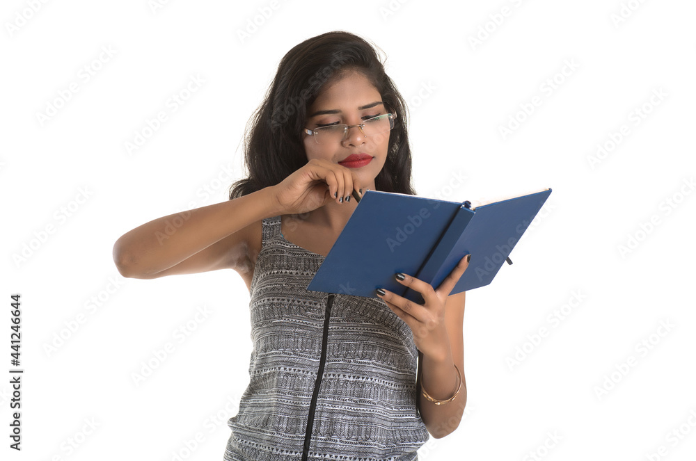 Pretty young girl holding book and posing on white background Pretty young girl holding book and posing on white background
