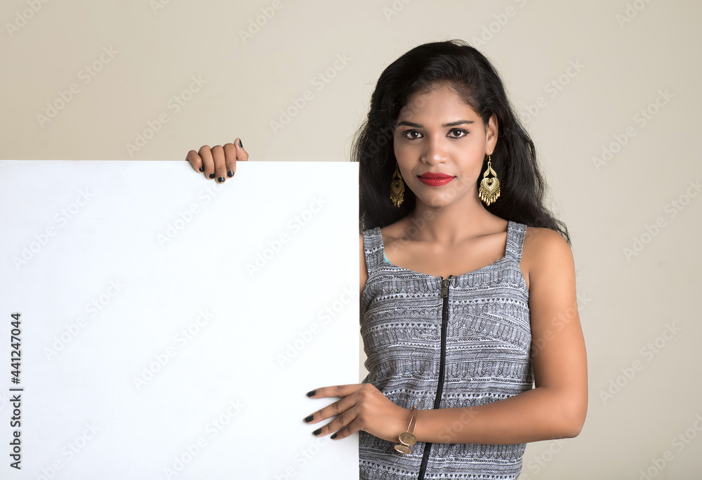 Beautiful young Girl holding white big signboard and posing Beautiful young Girl holding white big signboard and posing