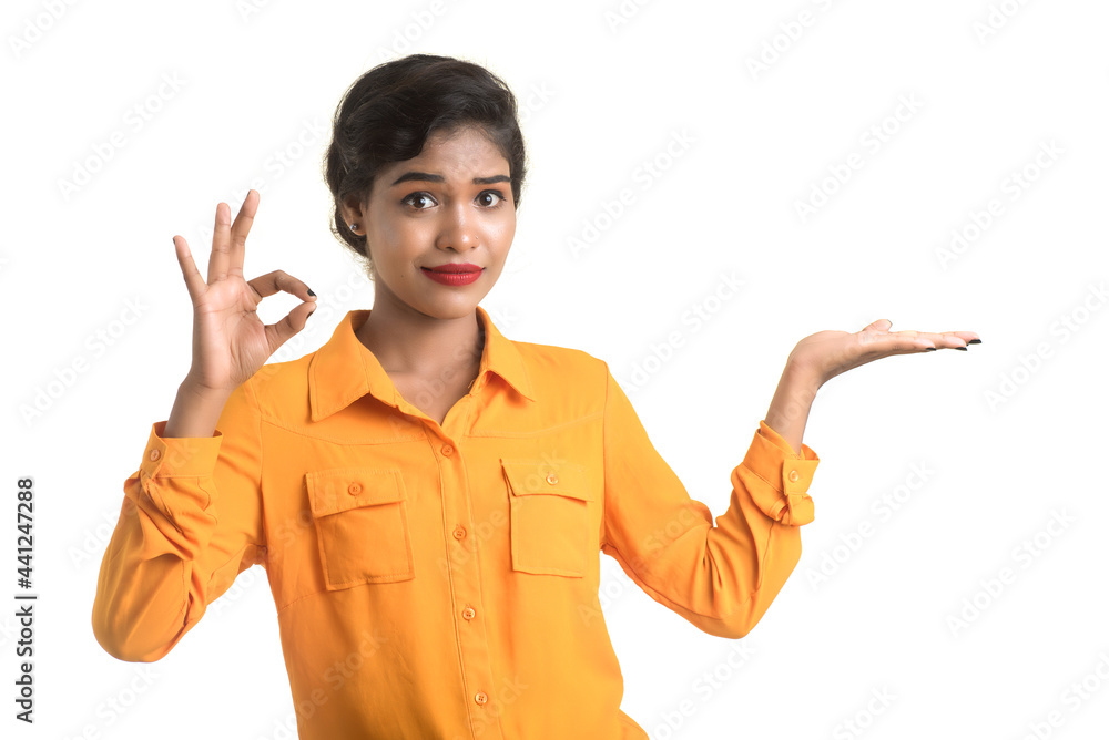 Beautiful girl holding and presenting something in the hand with happy smiling. Beautiful girl holding and presenting something in the hand with happy smiling.