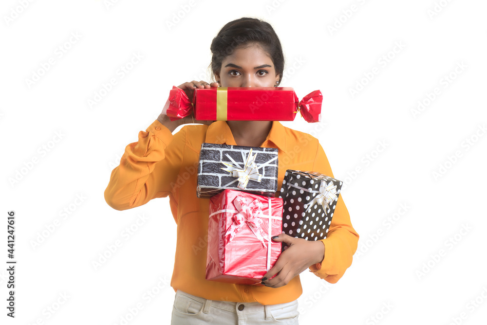 Portrait of young happy smiling Indian Girl holding gift boxes on a white background. Portrait of young happy smiling Indian Girl holding gift boxes on a white background.