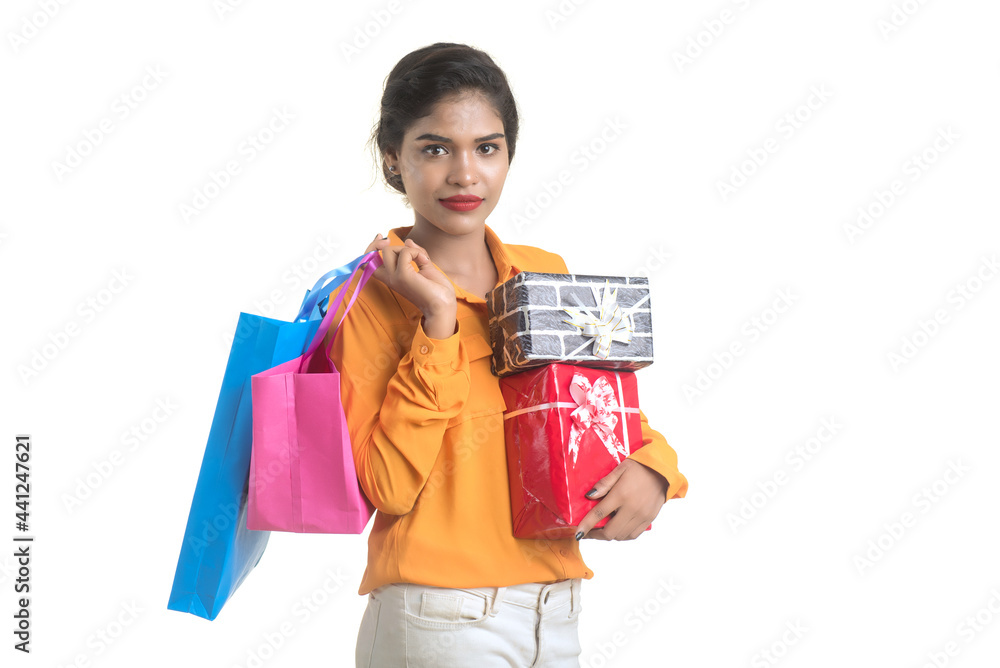 Beautiful woman carrying many shopping bags and gift Box on a white background. Beautiful woman carrying many shopping bags and gift Box on a white background.
