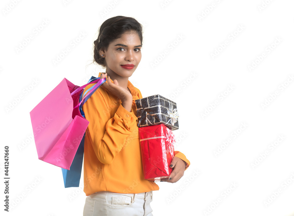 Beautiful woman carrying many shopping bags and gift Box on a white background. Beautiful woman carrying many shopping bags and gift Box on a white background.