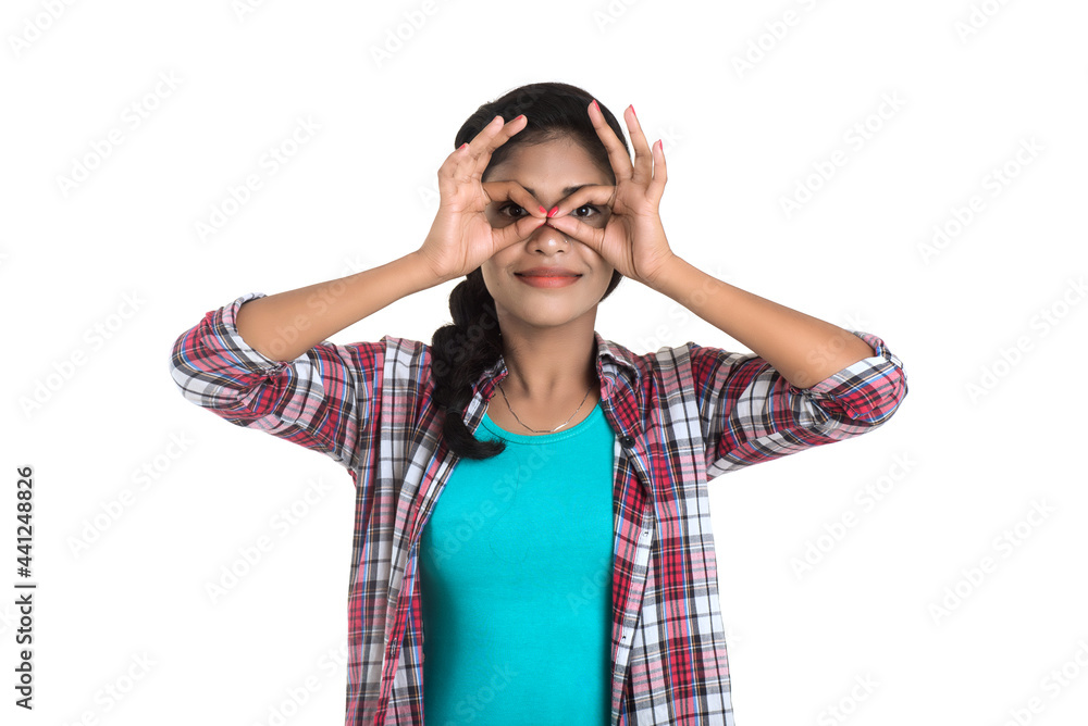 young woman looking at camera through fingers in ok gesture. Imitating binoculars over white background young woman looking at camera through fingers in ok gesture. Imitating binoculars over white background