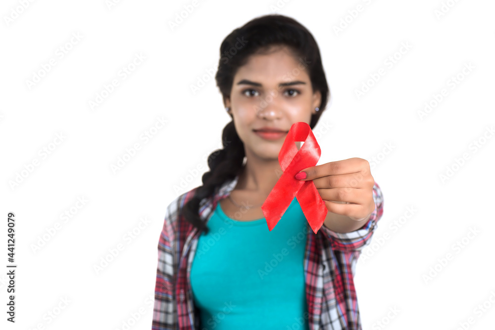 Young woman showing red ribbon HIV, AIDS awareness ribbon, healthcare and medicine concept Young woman showing red ribbon HIV, AIDS awareness ribbon, healthcare and medicine concept
