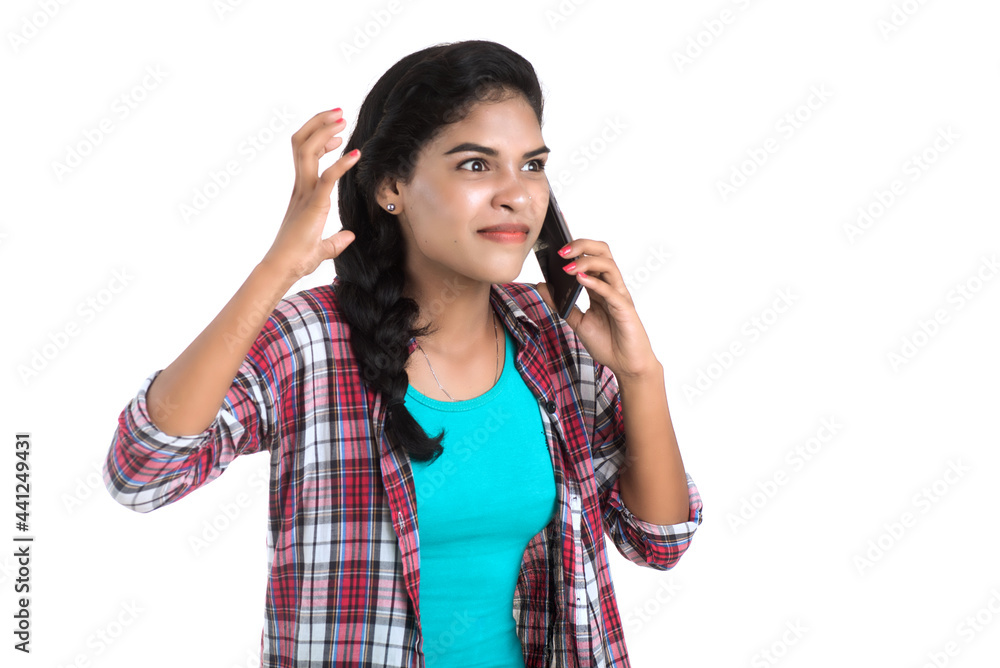 Young Indian girl using a mobile phone or smartphone isolated on a white background Young Indian girl using a mobile phone or smartphone isolated on a white background