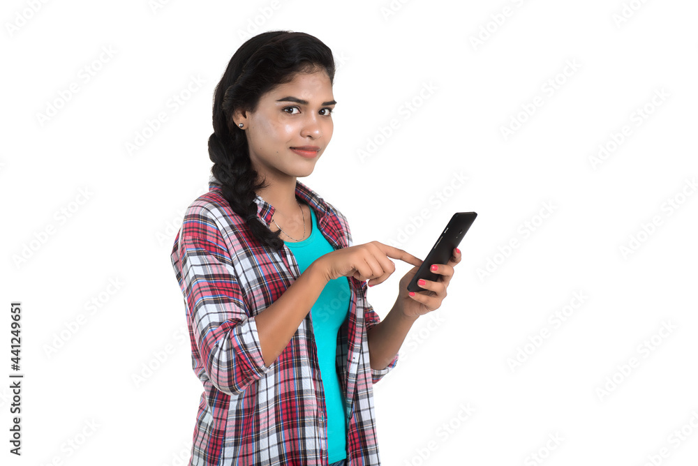 Young Indian girl using a mobile phone or smartphone isolated on a white background Young Indian girl using a mobile phone or smartphone isolated on a white background
