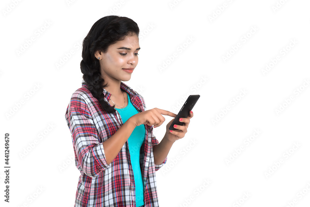 Young Indian girl using a mobile phone or smartphone isolated on a white background