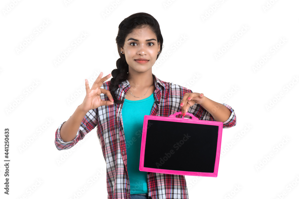 Beautiful young girl holding or posing with a chalkboard slate on a white background Beautiful young girl holding or posing with a chalkboard slate on a white background