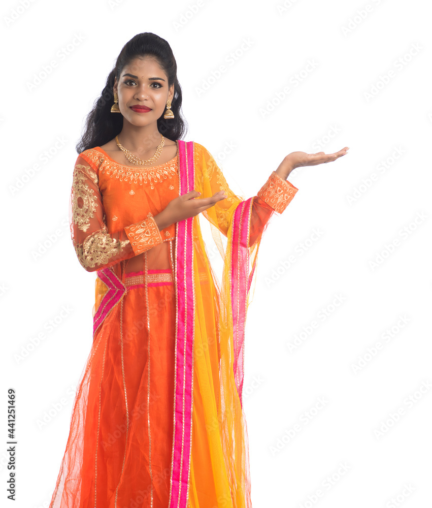 Portrait of cheerful Indian traditional young woman presenting something on hand, showing copy space on her palm on a white background Portrait of cheerful Indian traditional young woman presenting something on hand, showing copy space on her palm on a white background