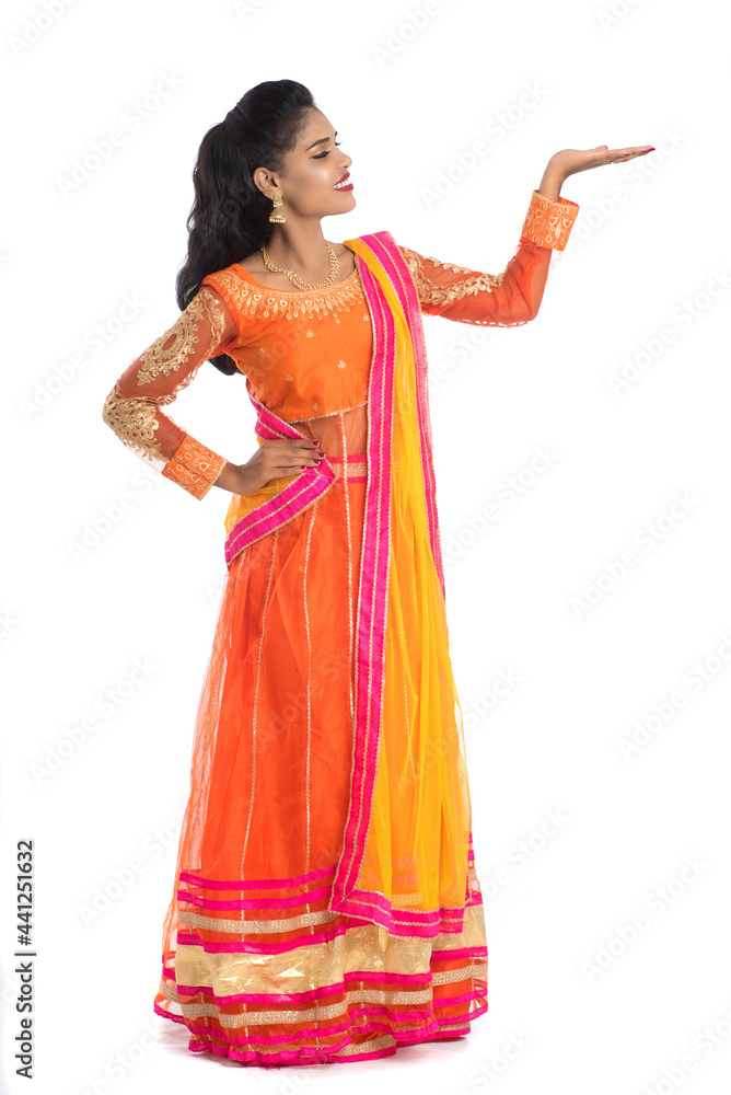 Portrait of cheerful Indian traditional young woman presenting something on hand, showing copy space on her palm on a white background Portrait of cheerful Indian traditional young woman presenting something on hand, showing copy space on her palm on a white background
