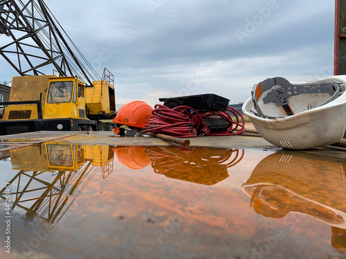 Reflection of helmet and crane falling into water at workplace