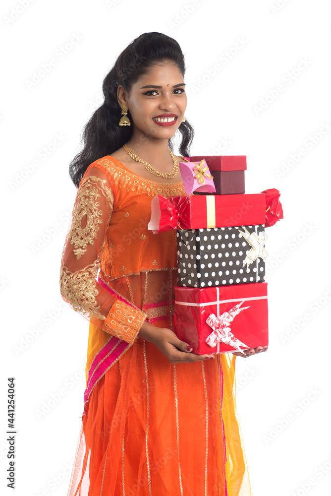 Portrait of young happy smiling Indian Girl holding gift boxes on a white background. Portrait of young happy smiling Indian Girl holding gift boxes on a white background.