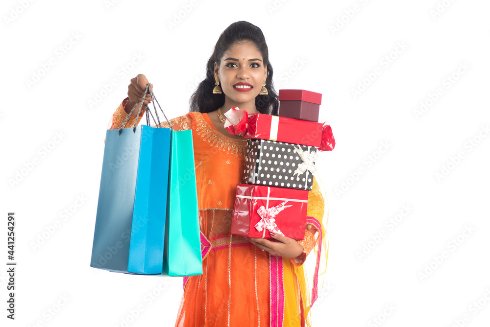 Beautiful woman carrying many shopping bags and gift Box on a white background. Beautiful woman carrying many shopping bags and gift Box on a white background.
