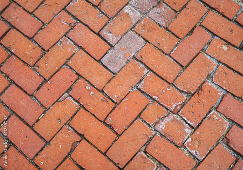 Background texture of decorative red brick terra cotta pavers in a herringbone pattern, design element.