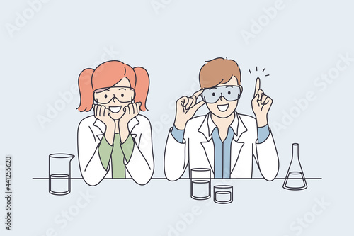 Laboratory research and tests for kids concept. Smiling happy small boy and girl children cartoon characters in white uniform sitting and making research tests with flasks together making innovations 