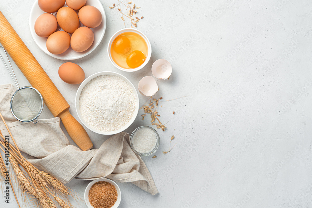 Flour, eggs, sugar, rolling pin on a gray background. Ingredients for baking. Flour, eggs, sugar, rolling pin on a gray background. Ingredients for baking.