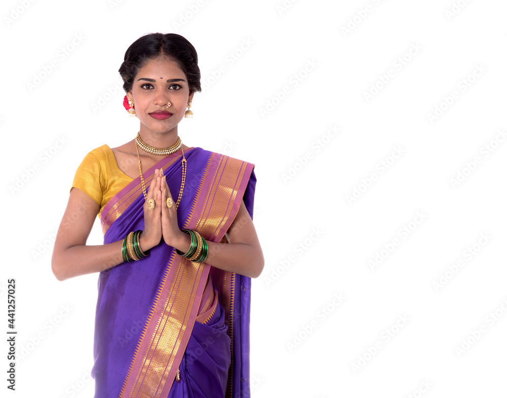 Young Indian girl in traditional clothing greeting namaste, Welcome, Indian girl in a tradition sari with welcome expression (inviting) Young Indian girl in traditional clothing greeting namaste, Welcome, Indian girl in a tradition sari with welcome expression (inviting)