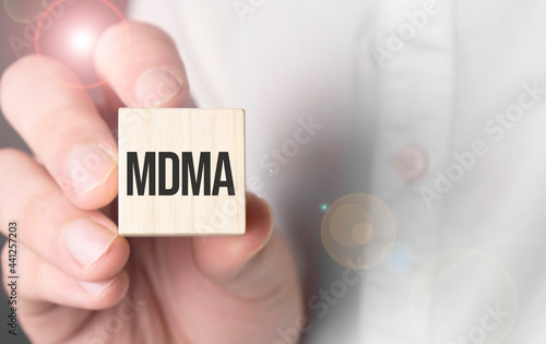 Man holding mdma word on wooden cube. photo