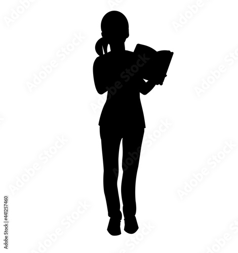 Silhouette of a teenage girl standing with an open book in her hands