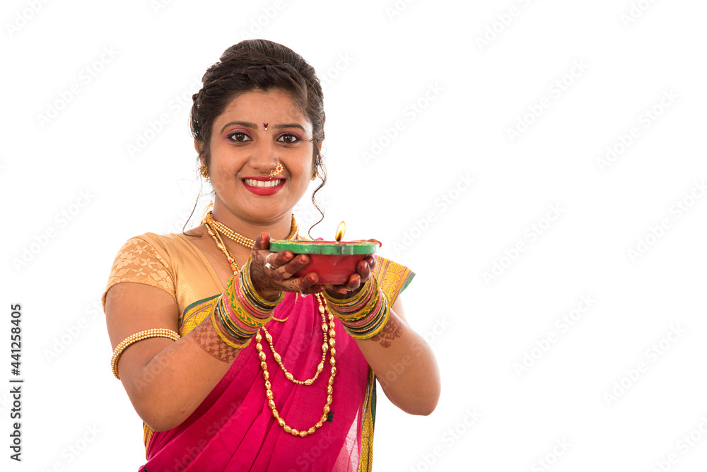 Portrait of a Indian Traditional Girl holding pooja thali with diya during festival of light on white background. Diwali or deepavali Portrait of a Indian Traditional Girl holding pooja thali with diya during festival of light on white background. Diwali or deepavali