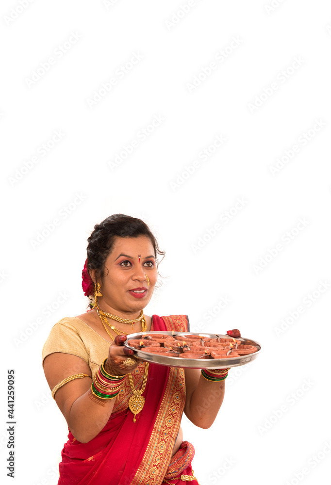 Portrait of a Indian Traditional Girl holding diya, Diwali or deepavali photo with female hands holding oil lamp during festival of light on white background Portrait of a Indian Traditional Girl holding diya, Diwali or deepavali photo with female hands holding oil lamp during festival of light on white background