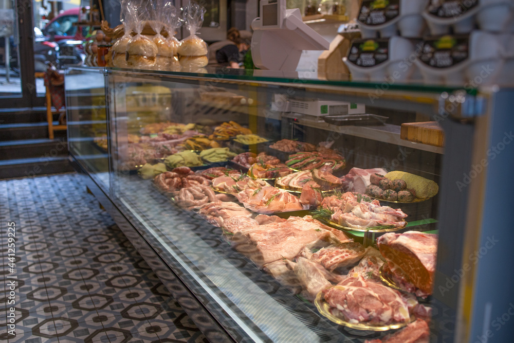 Showcase with raw farmer meat in butcher shop
