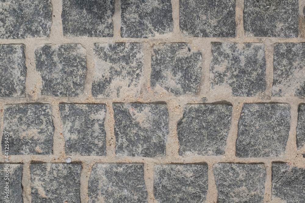 From above, a view of the cobblestone street . The texture of the stone pavement. Granite stones. From above, a view of the cobblestone street . The texture of the stone pavement. Granite stones.
