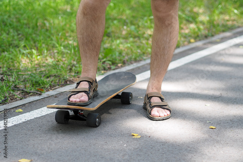 the man on the longboard is wearing sandals © dmitry767