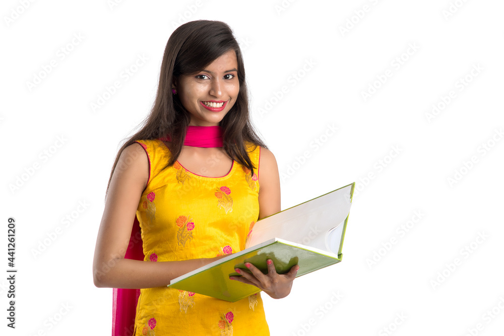 Pretty young girl holding book and posing on white background Pretty young girl holding book and posing on white background