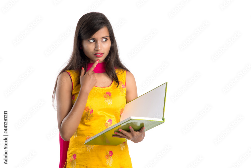 Pretty young girl holding book and posing on white background Pretty young girl holding book and posing on white background