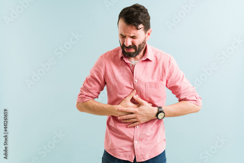 Hispanic man with a stomach problem photo