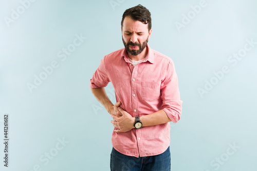 Distressed man suffering from spleen pain photo