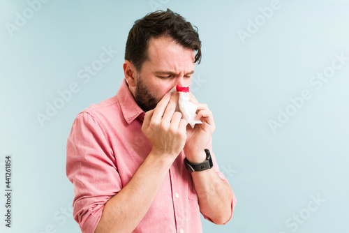 Young man blowing his nose with blood