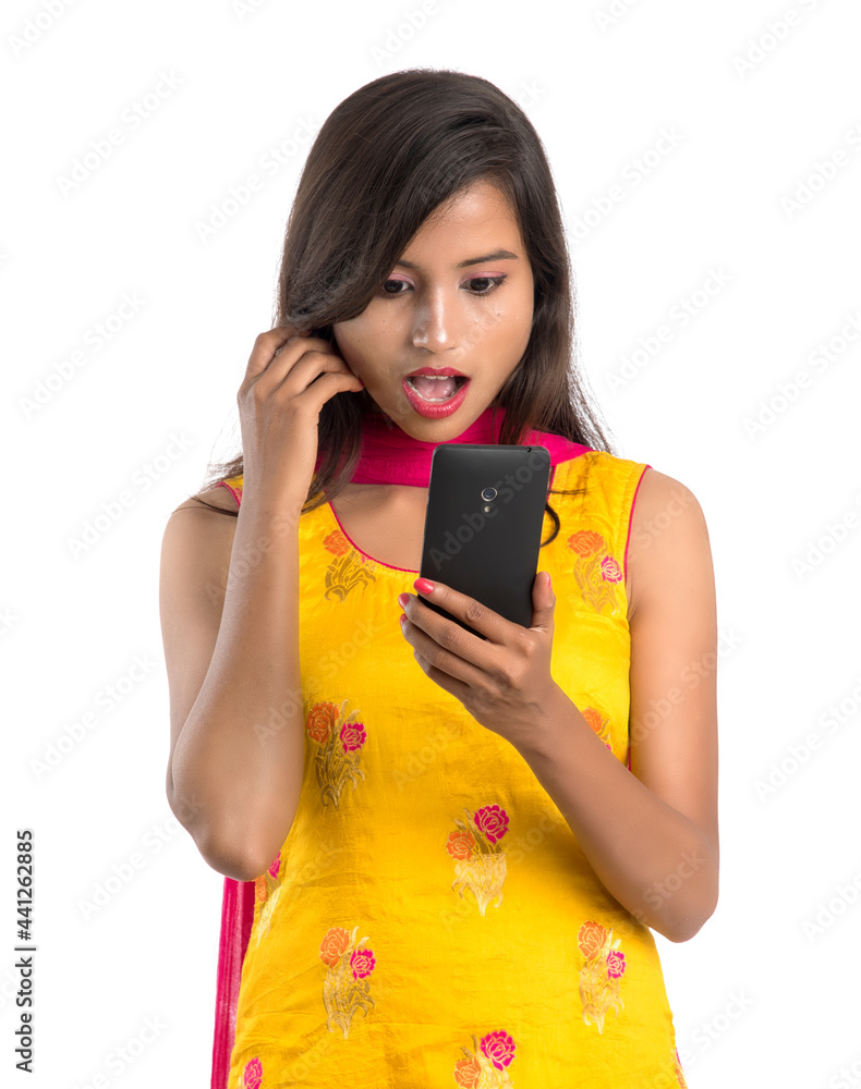 Young Indian girl using a mobile phone or smartphone isolated on a white background Young Indian girl using a mobile phone or smartphone isolated on a white background