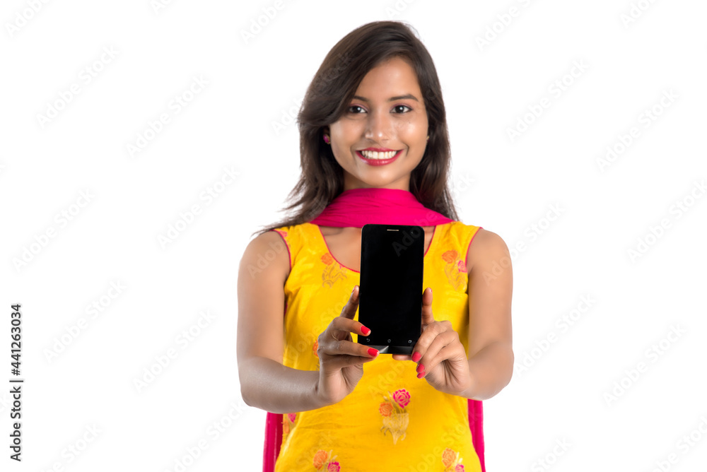 Young beautiful woman holding and showing blank screen smartphone or mobile or tablet phone on a white background. Young beautiful woman holding and showing blank screen smartphone or mobile or tablet phone on a white background.
