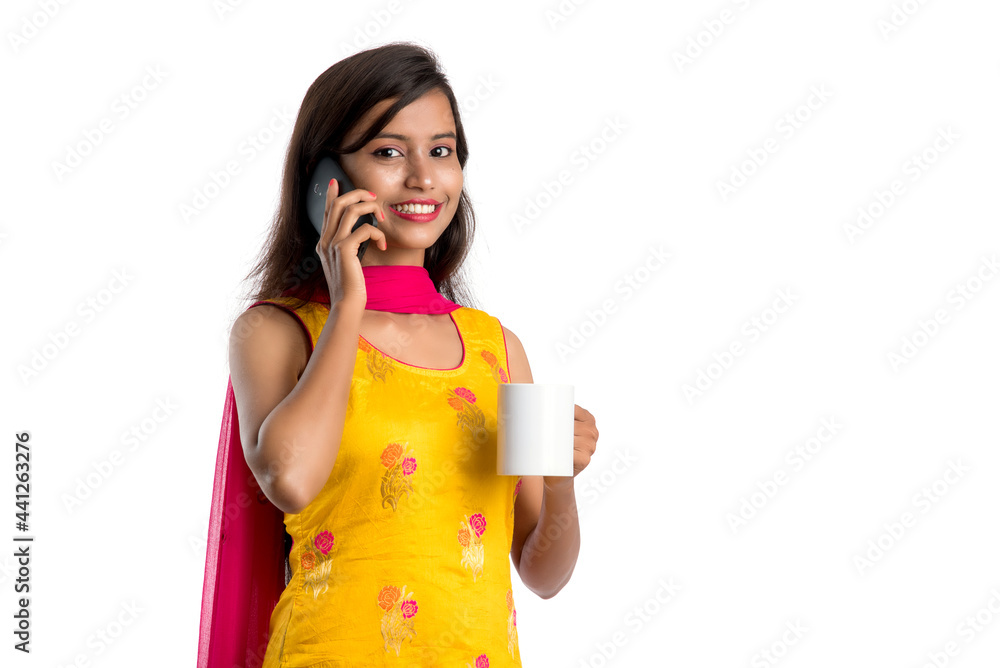 Pretty young girl calling on smartphone device while drinking tasty coffee or tea beverage Pretty young girl calling on smartphone device while drinking tasty coffee or tea beverage
