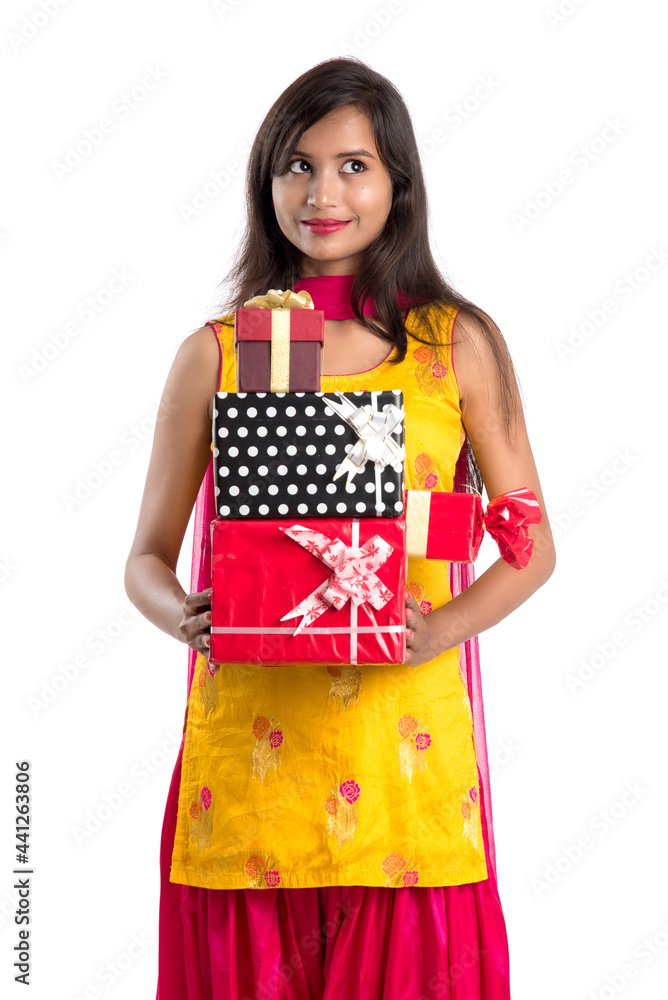 Portrait of young happy smiling Indian Girl holding gift boxes on a white background. Portrait of young happy smiling Indian Girl holding gift boxes on a white background.