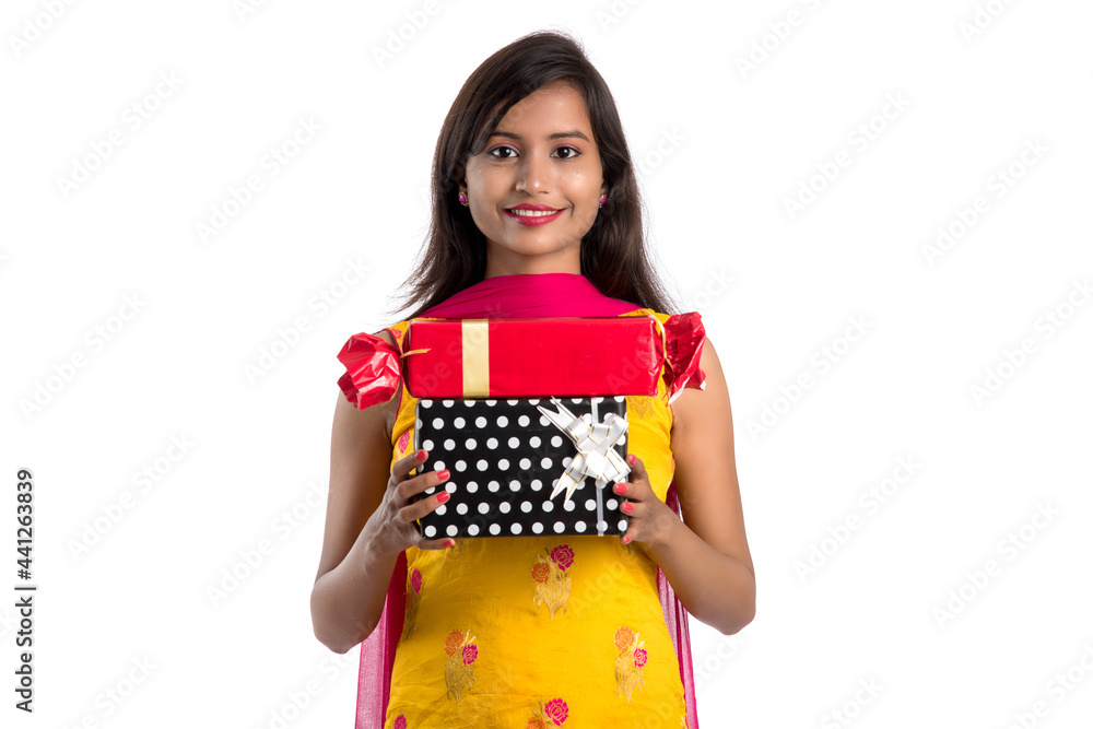 Portrait of young happy smiling Indian Girl holding gift boxes on a white background. Portrait of young happy smiling Indian Girl holding gift boxes on a white background.