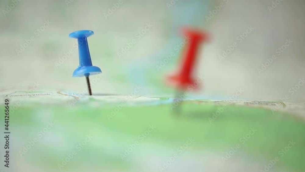 Man use pinned travel map and color pins at some location where he want to be Man use pinned travel map and color pins at some location where he want to be