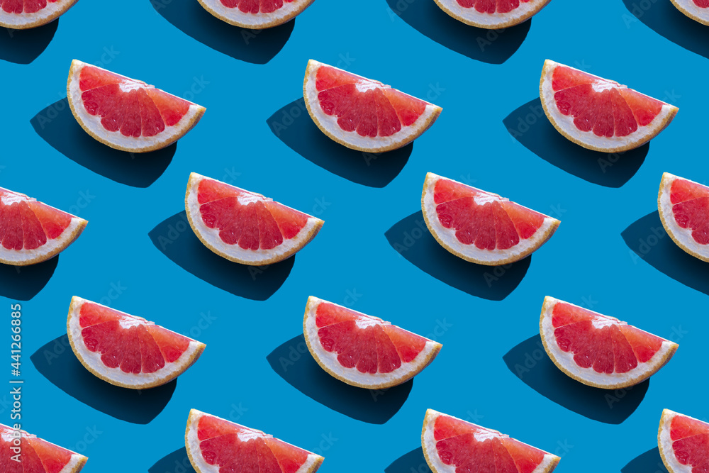 Seamless pattern of orange grapefruit with shadow on a blue background. Minimal trendy summer vacation concept. Healthy eating lifestyle. Seamless pattern of orange grapefruit with shadow on a blue background. Minimal trendy summer vacation concept. Healthy eating lifestyle.