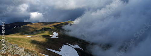 Beautiful scenic view in a rainy and cloudy day over the Transalpina road, the highest mountain road in the Carpathians located in the Parang mountains, Romania, Europe