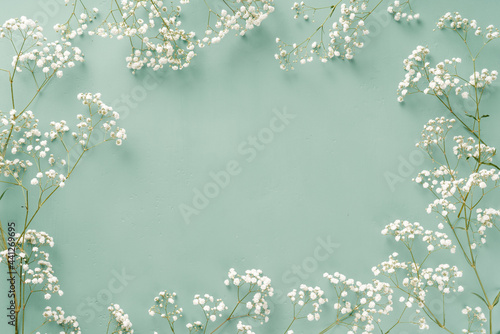 Flowers composition. White flowers on turquoise blue background. Wedding mockup with small flowers. Flat lay, top view, frame. Gypsophila Baby's-breath flowers © Tatyana Sidyukova