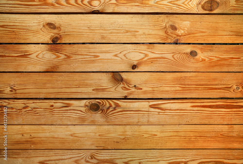 Wall made of old varnished wooden panels with multiple knots as a background. Wall made of old varnished wooden panels with multiple knots as a background.