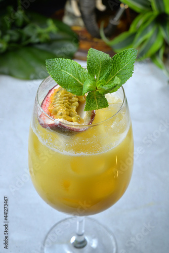 Cocktail with passion fruit and mango tropic background closep -
