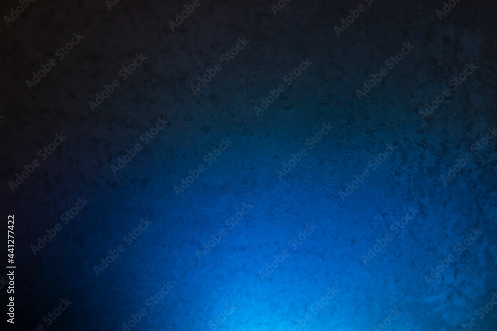 The concrete wall is illuminated by a blue lamp. The concrete wall is illuminated by a blue lamp.