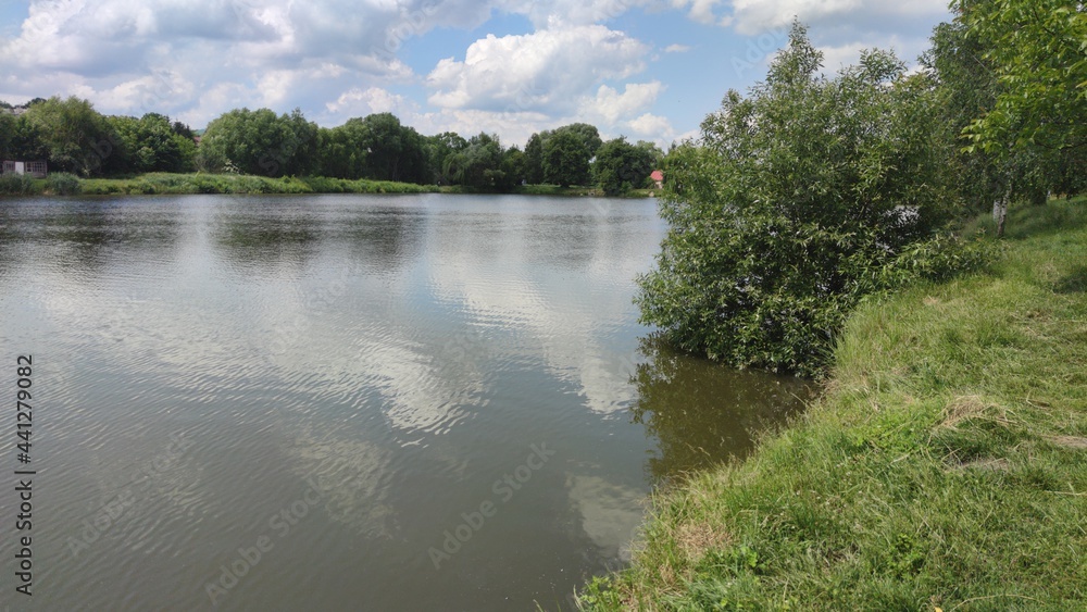 Landscape with a lake and clouds on the sky in the summer season