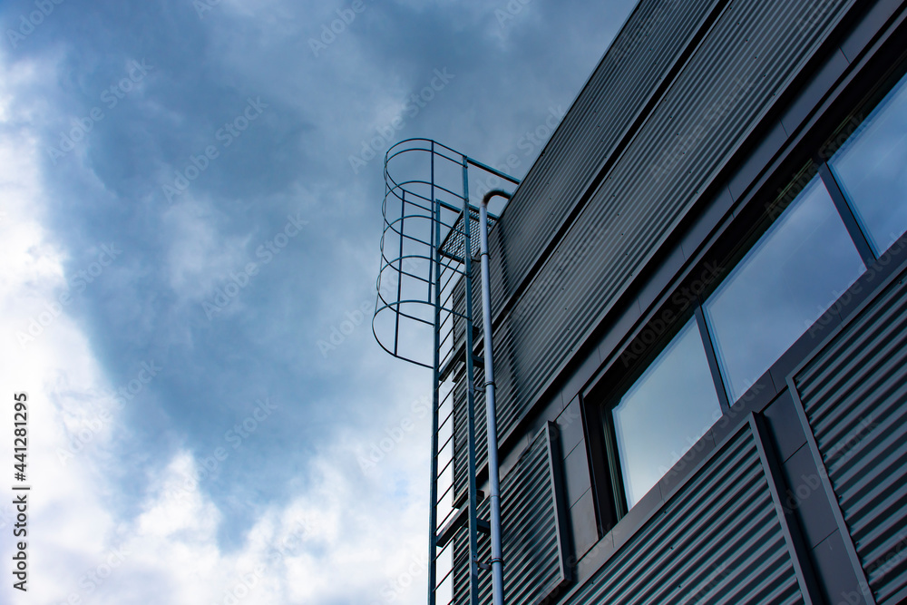 Stairway to Heaven. Metal staircase on the building against the background of the sky and clouds.