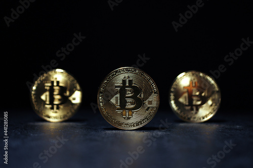 Three Gold Bitcoins Side By Side Standing On A Glossy Surface, Digital Currency, Cryptocurrency Trading © artbase