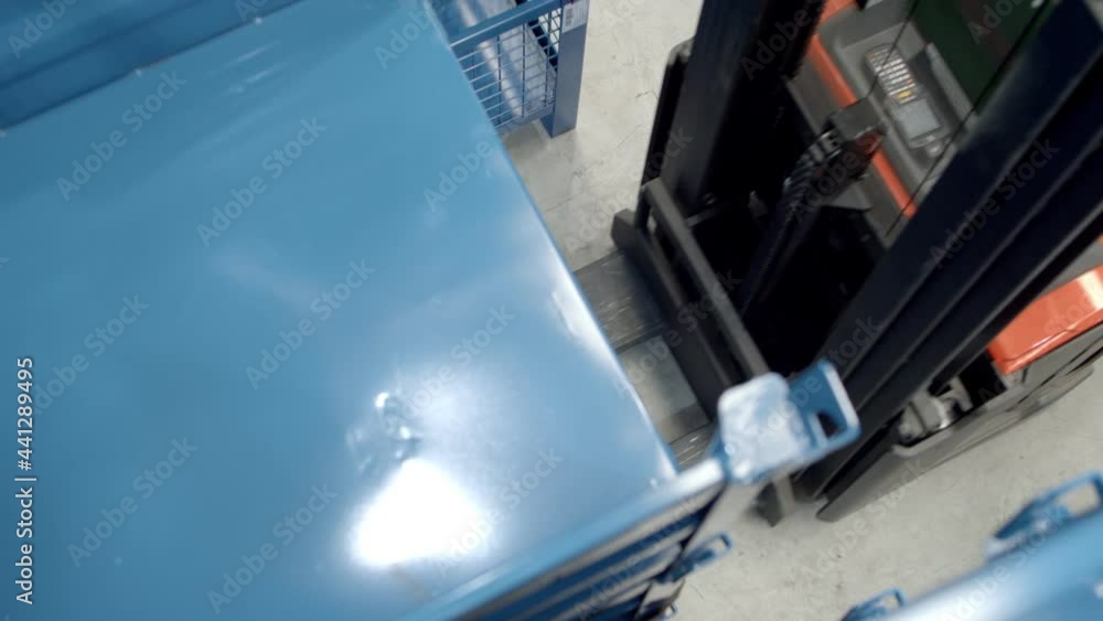 Forklift pulls beneath camera to lift and move shelves, high angle Forklift pulls beneath camera to lift and move shelves, high angle